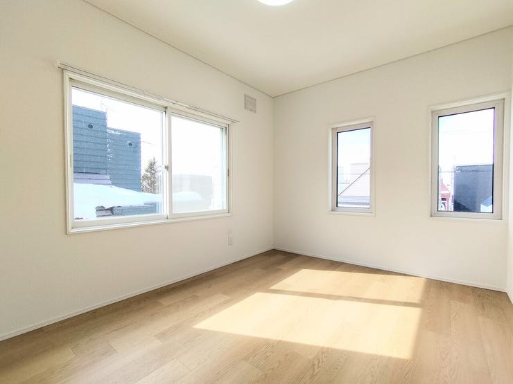 大きな窓から明るい光が差し込む洋室