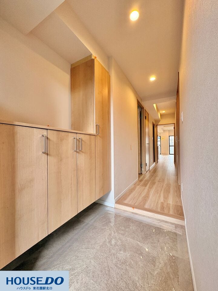 廊下の先には明るいリビングが広がり、住まい全体の風通しの良さが伝わります。天井にはダウンライトが等間隔に配置され、夜間も柔らかな光で足元を照らします。各部屋へのアクセスが良い機能的な配置です。