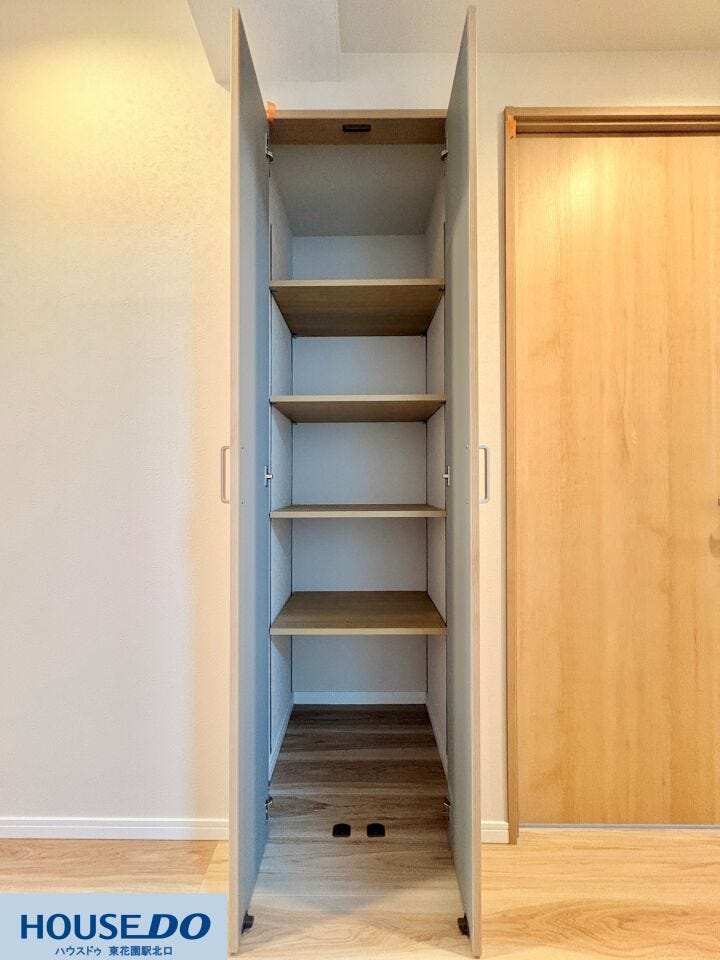 リビングの動線上に配置された、高さ調節が可能な棚付き収納です。掃除道具や日用品のストック、書類関係など、生活感の出やすい小物を隠して収納できるため、お部屋の美観を保つのに役立ちます。