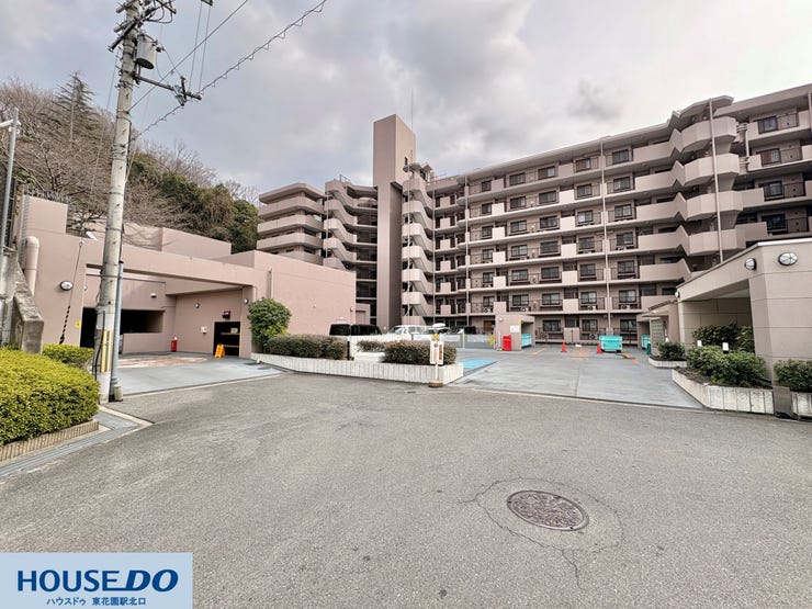 建物の背後には豊かな緑が広がり、落ち着いた環境で過ごせます。敷地内の通路や平置きの駐車場スペースはゆとりを持って設計されており、お車の出し入れや、大きな荷物を持っての移動もスムーズに行える造りです。