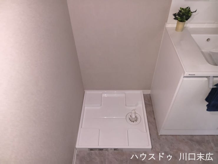 防水パンを備えた洗濯機スペース。水漏れのリスクを軽減し、日々の家事動線を考慮した機能的な造りとなっています。