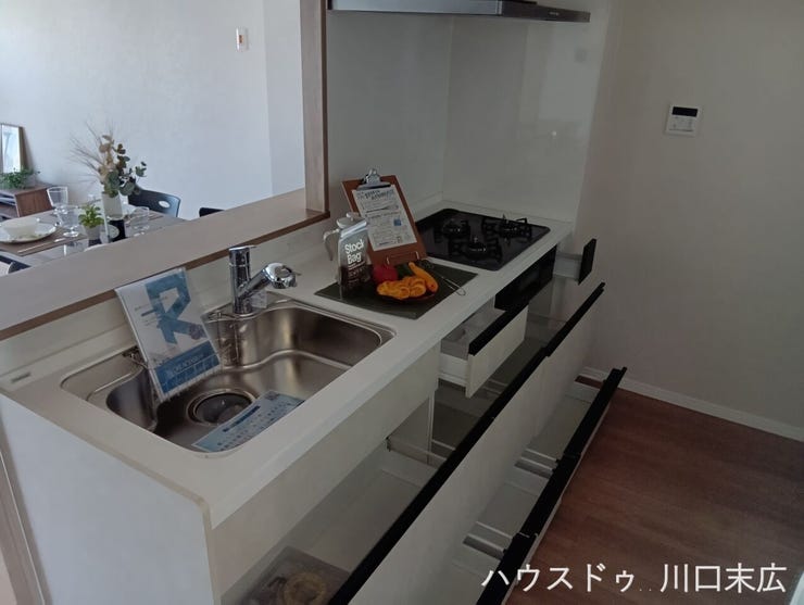 調理器具や食器類を奥まで見渡せる引き出し式収納を備えたシステムキッチン。出し入れがスムーズに行え、日々の家事効率を向上させる機能美です。