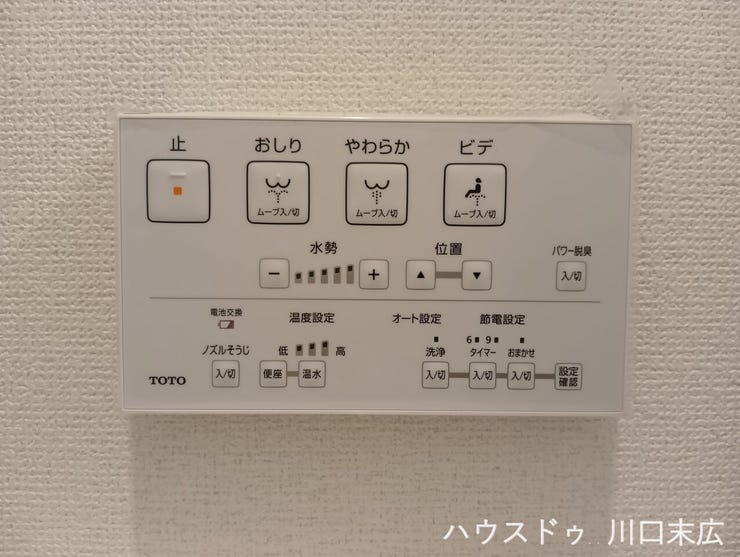 壁面にすっきりと設置された温水洗浄便座のリモコン。水勢や温度の調節など、多彩な機能を直感的に操作できるパネルデザインで、快適なトイレ環境をスマートに実現します。