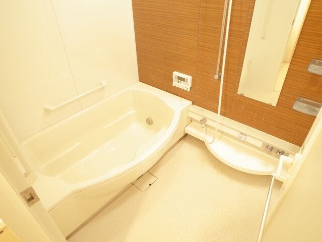 浴槽のやわらかなカーブが、やさしい雰囲気と入りやすさを演出。木目調のアクセントパネルで、心ほぐれるバスタイムに。