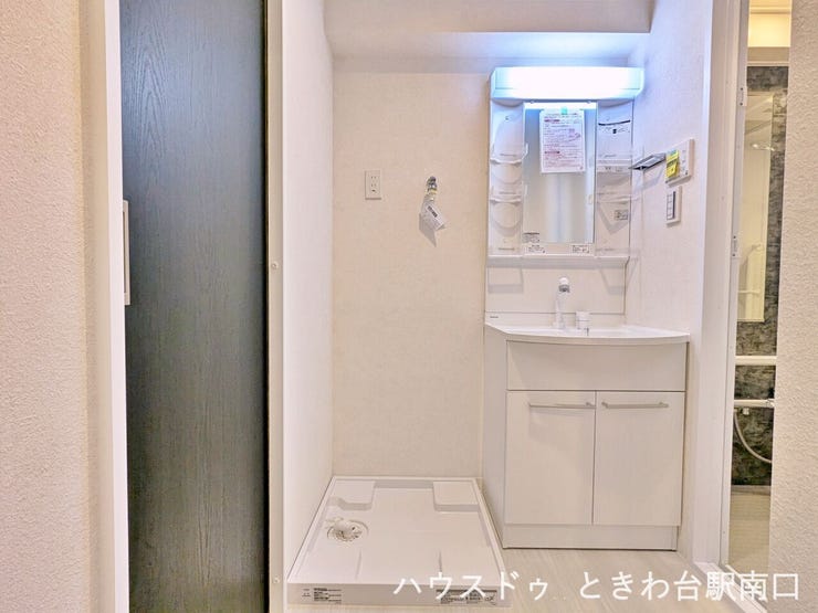 白を基調とした明るく衛生的なサニタリースペース。使いやすいシャワー付き洗面化粧台の横には洗濯機置場があり、家事動線もスムーズです。鏡裏や足元の収納など、細やかな配慮が光る設計となっています。