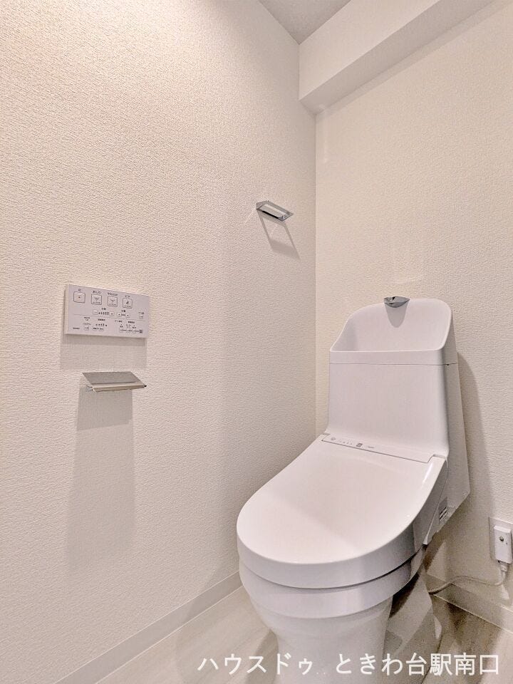 空間を広く感じさせるスリムなデザインのトイレ。お手入れが容易な形状で、日々の清掃負担を軽減します。上部には棚板を設置しており、ストック品を置くのにも便利。機能性と清潔感を両立した空間です。