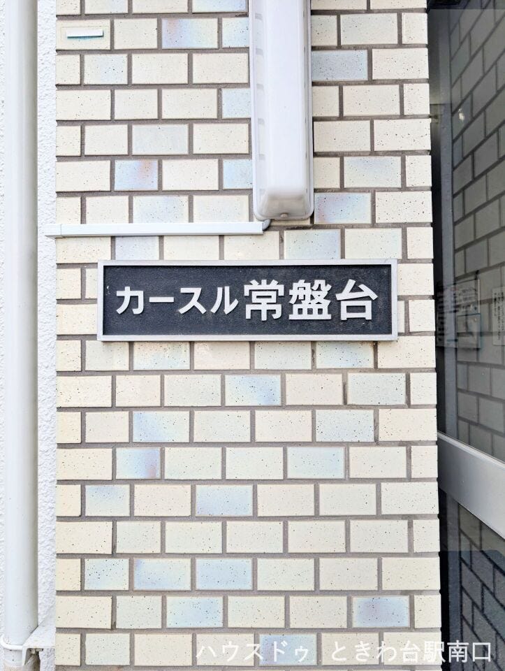 館名プレートがエントランス付近に設置され、来客時にも分かりやすい仕様。建物の管理体制が感じられるポイントです。