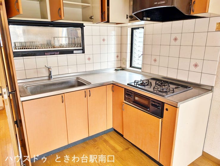 L字型システムキッチンは3口コンロ付きで調理効率ばっちり。収納力も豊富で、快適に料理を楽しめる機能的な空間です。