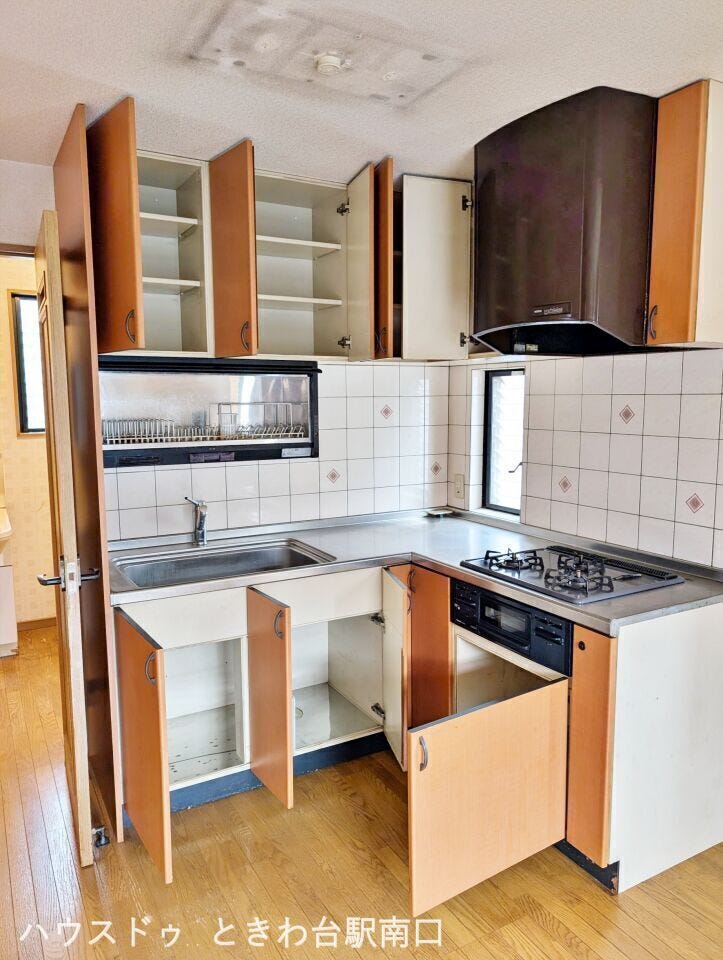 上下に充実した収納を備えたL字型キッチン。調理器具や食器をすっきり整理でき、広々とした調理スペースで快適に料理可能。