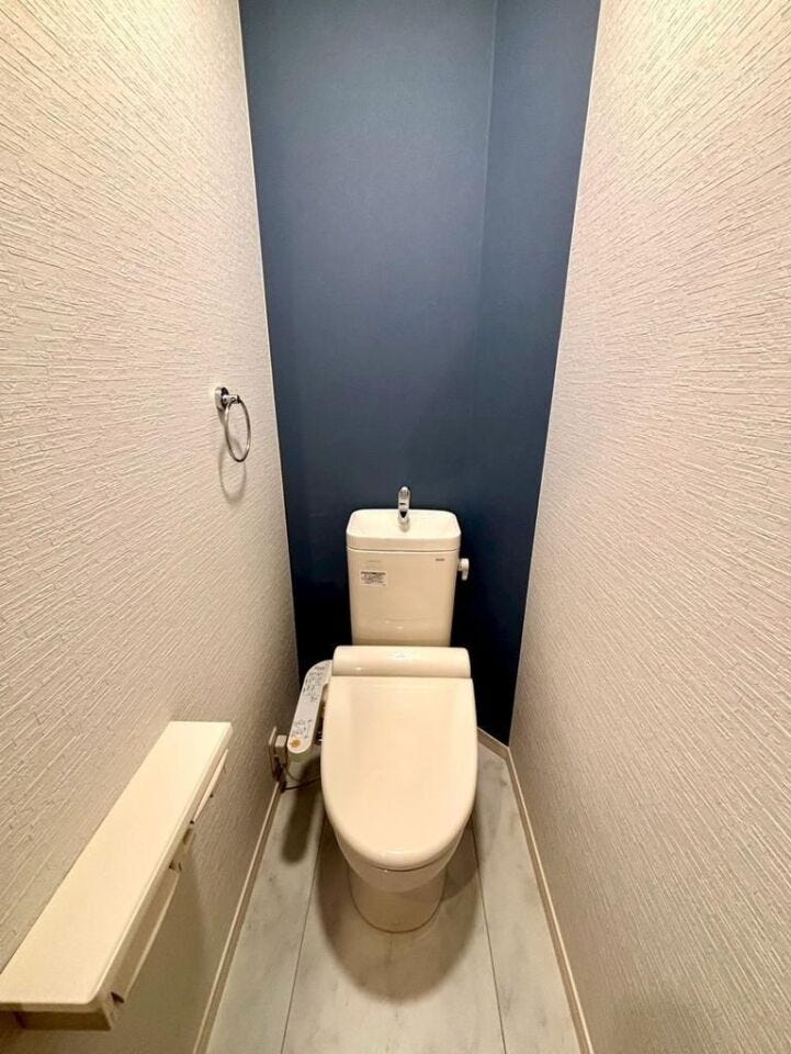 落ち着いた配色のトイレ空間。温水洗浄便座付きで快適に使用できます。