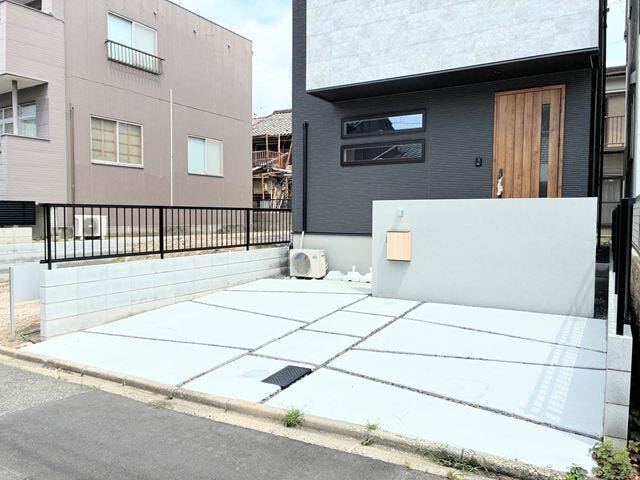 コンクリート敷きで足元まで美しい駐車場。モダンなデザイン門柱が玄関前を彩ります