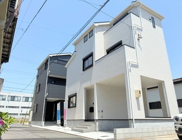 清潔感のあるホワイトの外壁に黒のサッシがアクセントを添える、洗練されたモダンな外観