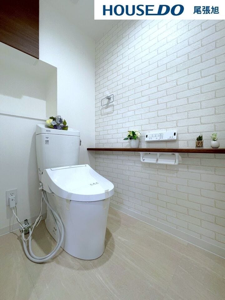 【トイレ】明るく、ひろびろとしたトイレです。アクセントクロスとちょっとしたカウンターはおしゃれに。後ろの収納があることで掃除もしやすく、いつでも綺麗を保てます。