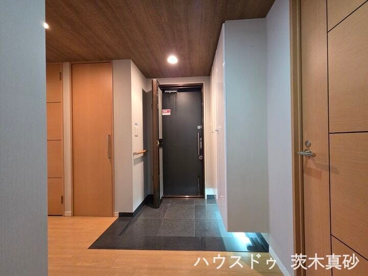 【間接照明が彩る上質な玄関先】
大容量シューズボックス下には足元を照らすフットライトを設置。
木目調の天井が高級感と温かみを演出するモダンな空間です。