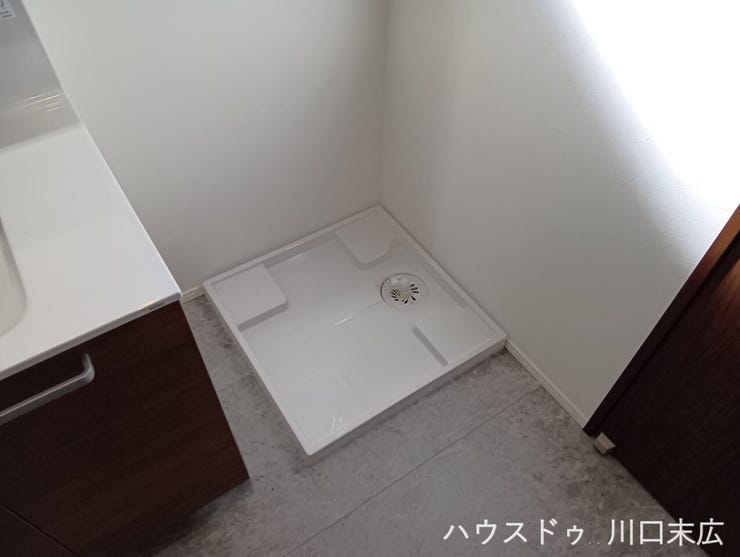 水漏れのリスクを軽減する洗濯機防水パンを備えたランドリースペース。洗面化粧台や浴室などの水回り設備を集約し、家事動線に配慮した設計です。