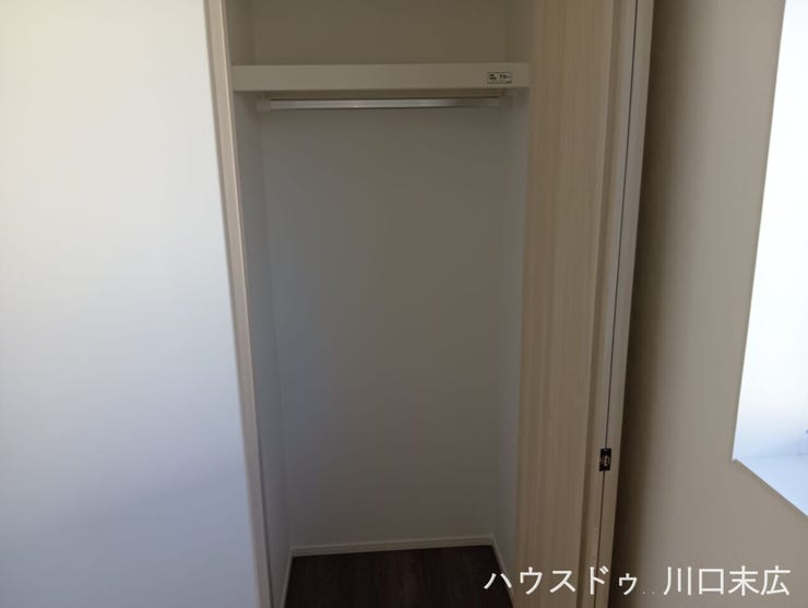 ハンガーパイプと枕棚を備えた機能的なクローゼット内部。丈の長いコートやワンピースから、季節の衣類、バッグなどの小物まで、機能的かつ美しく収納できます。