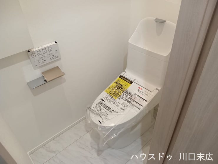 温水洗浄便座を備えた清潔感のあるレストルーム。手洗い付きのタンクを採用し、機能性にも優れています。