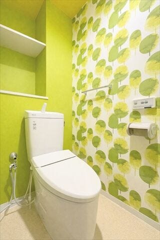 爽やかなグリーンのアクセントクロスが印象的なトイレ。明るく清潔感のある空間です。