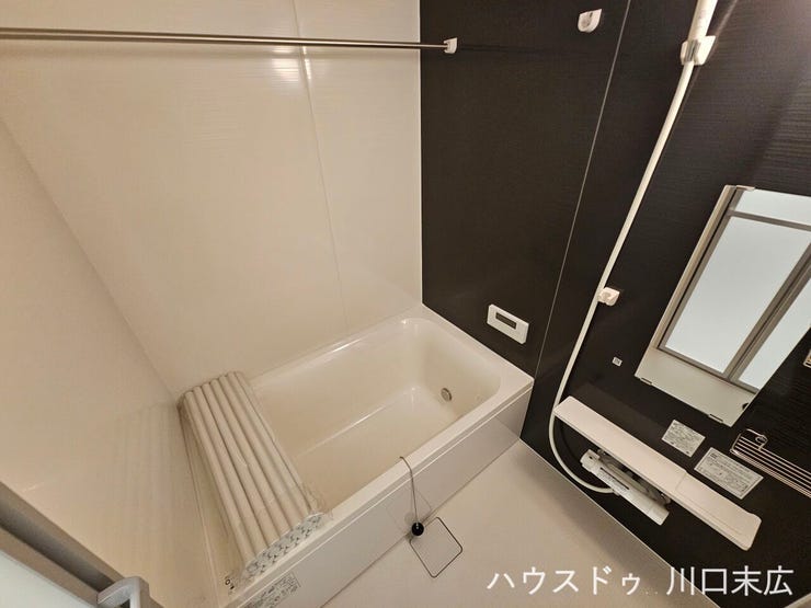 シックなアクセントパネルが落ち着いたリラックスタイムを演出するユニットバス。機能的な収納棚やスライドバーを備え、快適なバスタイムを過ごせる清潔感のある空間です。