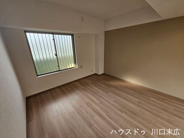 壁一面に落ち着いた色合いのアクセントクロスをあしらい、空間に洗練された表情を与える洋室。寝室や書斎など、ライフスタイルに合わせて多様な使い方が可能な一室です。