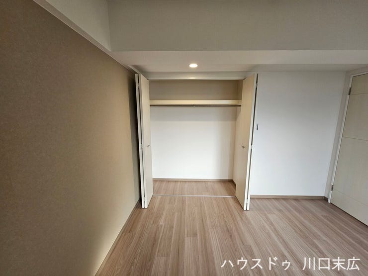 衣類をシワなく掛けられるパイプハンガーと、上部に枕棚を備えたクローゼット。折れ戸を採用することで開閉スペースを抑え、居室の有効面積を広々と活用できる設計です。