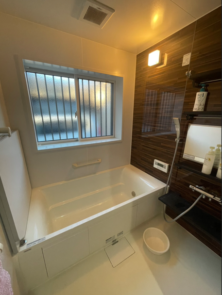 洗面所との統一感を持たせた浴室のおしゃれな壁。