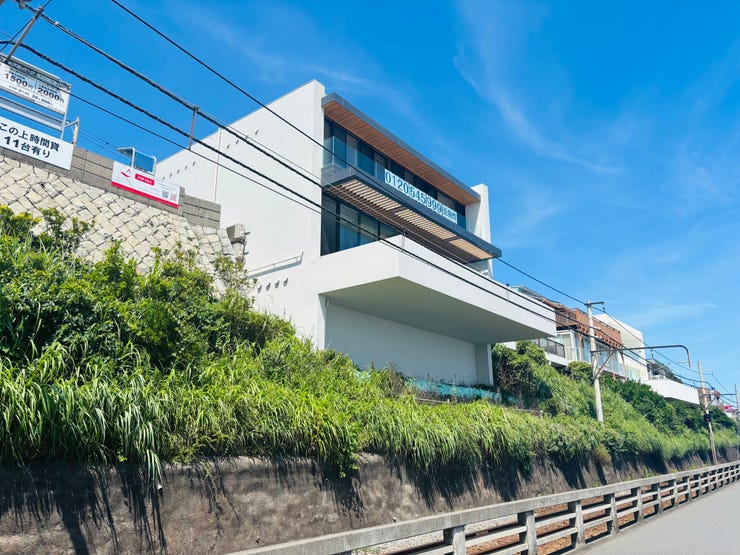 七里ガ浜の最前列に佇む、モダンな意匠を纏った邸宅。幅員約5.5mのゆとりある前面道路に面し、プライバシーを確保しながらも、街並みのランドマークとなる気品溢れる佇まいを誇ります。