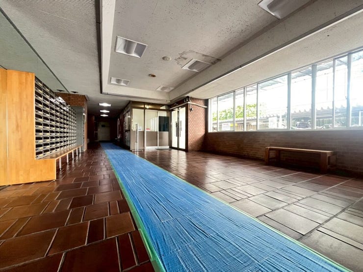 大きな連続窓から自然光を取り込むエントランスホールです。床面は落ち着いた色調のタイルで構成されています。