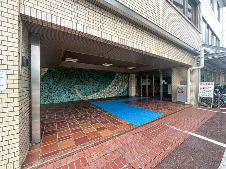 外壁は明るい色調のタイル張りで、広く確保された屋根付きのエントランスアプローチです。段差のないフラットな床面による、スムーズな通行が可能な構造です。