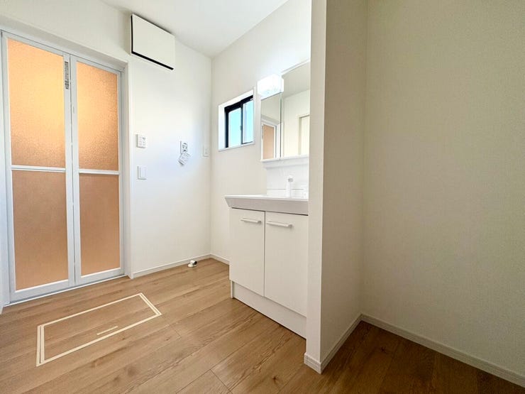 脱衣所にゆとりがあり、着替えや洗濯の動作がスムーズです。洗濯カゴや収納棚を置いても圧迫感がなく、家事動線も整えやすい快適な空間です。