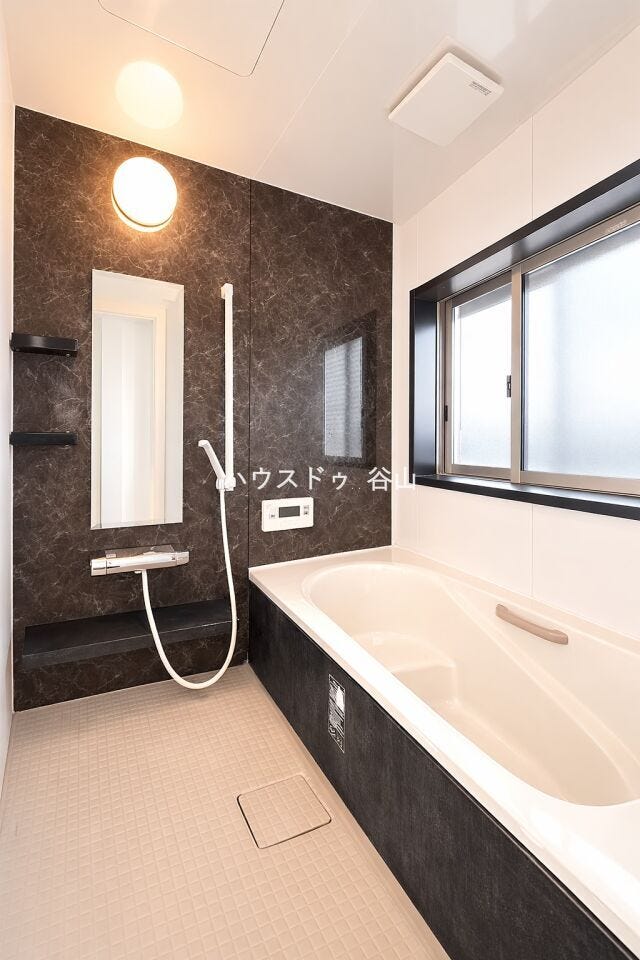 窓付きで換気しやすく、落ち着いたアクセントパネルが印象的な浴室空間です。