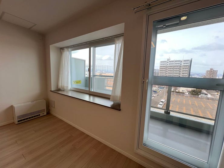 大きな窓からたっぷりの自然光が差し込み、お部屋全体を明るく開放的な空間に演出します。バルコニー越しに広がる街の景色を眺めながら、ゆったりと寛げます。