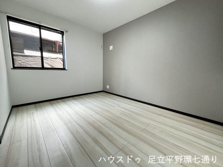 大きな窓から陽光が差し込む明るい洋室。バルコニーに面しており、開放感のある快適な住空間です。
