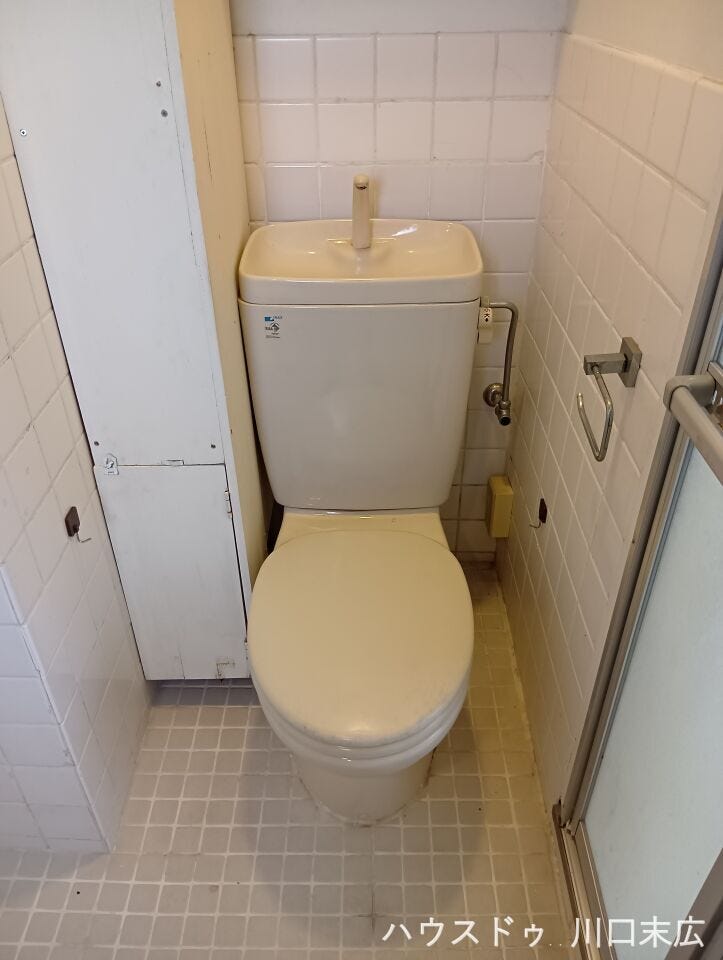 手洗い器付きのタンクを備えたトイレ設備です。独立したプライベート空間として、シンプルで無駄のない機能的な造りになっています。