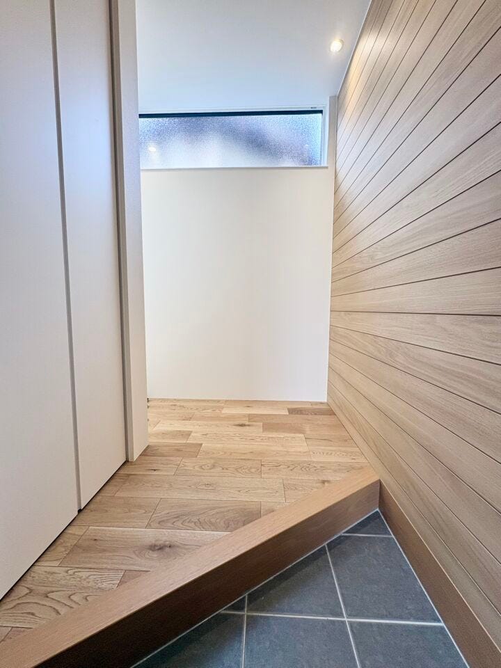 木目調のフローリングと壁のデザインを統一することで、空間全体に温かみのある落ち着いた雰囲気が広がります。ご家族をやさしく包み込む温かみを感じられる空間になっています。