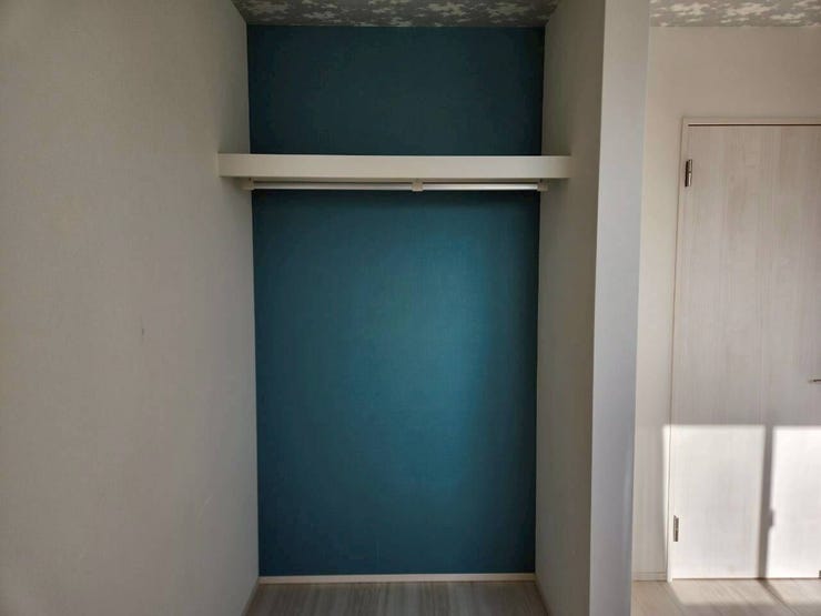 ブルーのアクセントクロスが目を引く、おしゃれな収納スペースです。