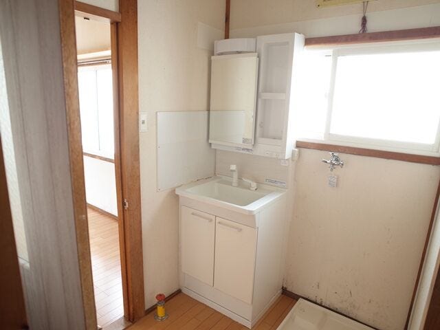 開き戸収納付きの一面鏡洗面台は、衣類の予洗いや軽い洗髪にも便利なシャワー水栓です。キッチンと廊下の両方から出入りでき、家事動線も良好です。