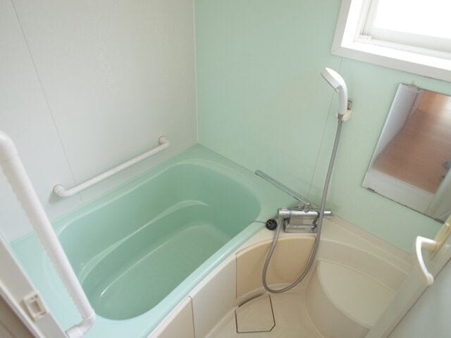 清涼感のあるミントグリーンの浴槽とアクセントパネルが印象的な浴室。開き戸で出入りしやすく、すっきりとリフレッシュできる空間です。