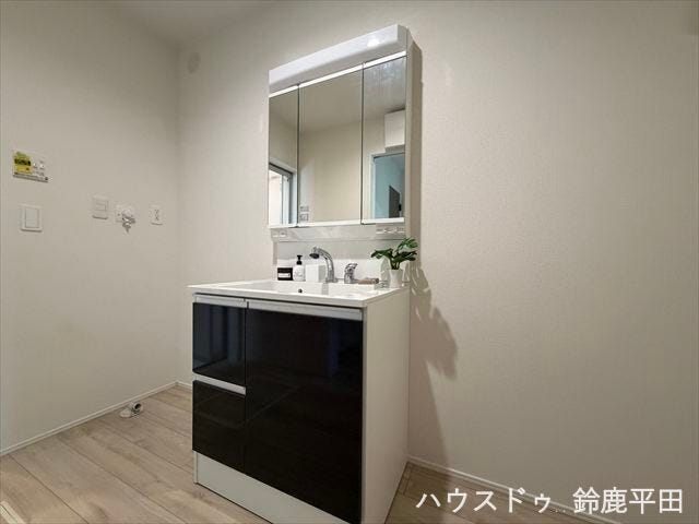 ゆとりある広さの洗面所で、洗濯機を置くスペースもあります。三面鏡と収納スペースを備えているので使い勝手のいい洗面台ですね。