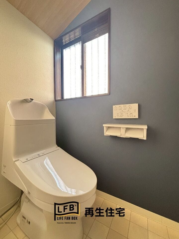 アクセントカラーのクロスが特徴のトイレ。窓からの自然光が差し込み、明るく衛生的な空間を保ちます。