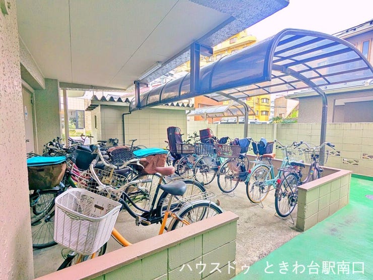 駐輪スペースは複数箇所に分かれており、住戸からの動線も考慮されています。地面はコンクリートで舗装され、足元が汚れにくい仕様です。