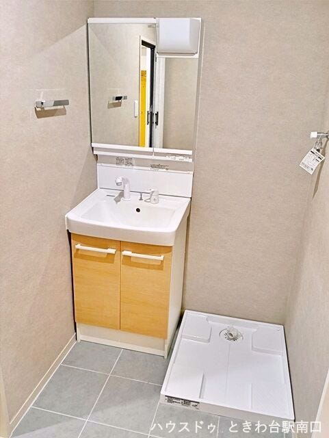 清潔感あふれる独立洗面台です。鏡の裏は収納になっており、洗面周りの小物を効率よく整理できます。横には洗濯機置き場も配置されており、家事動線に優れた機能的なサニタリースペースとなっています。