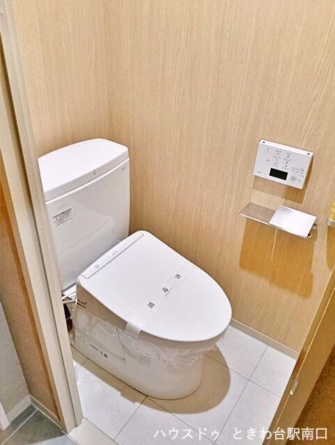 木目調の壁紙を採用した、個室感のある落ち着いたトイレです。手洗い付きのタンクや温水洗浄便座など、快適な使用感にこだわった設備を整えています。