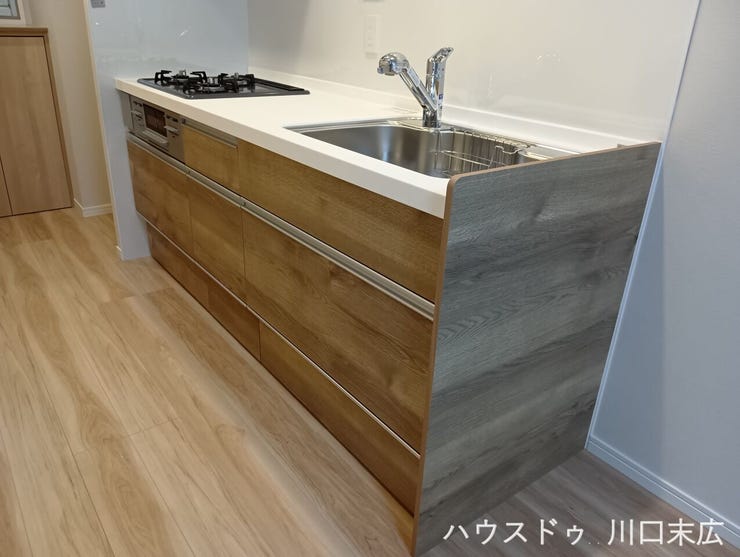 インテリアに馴染む美しい木目調パネルを採用したシステムキッチン。家事のモチベーションを高める洗練されたデザインと、使い勝手を考慮した設備が魅力です。