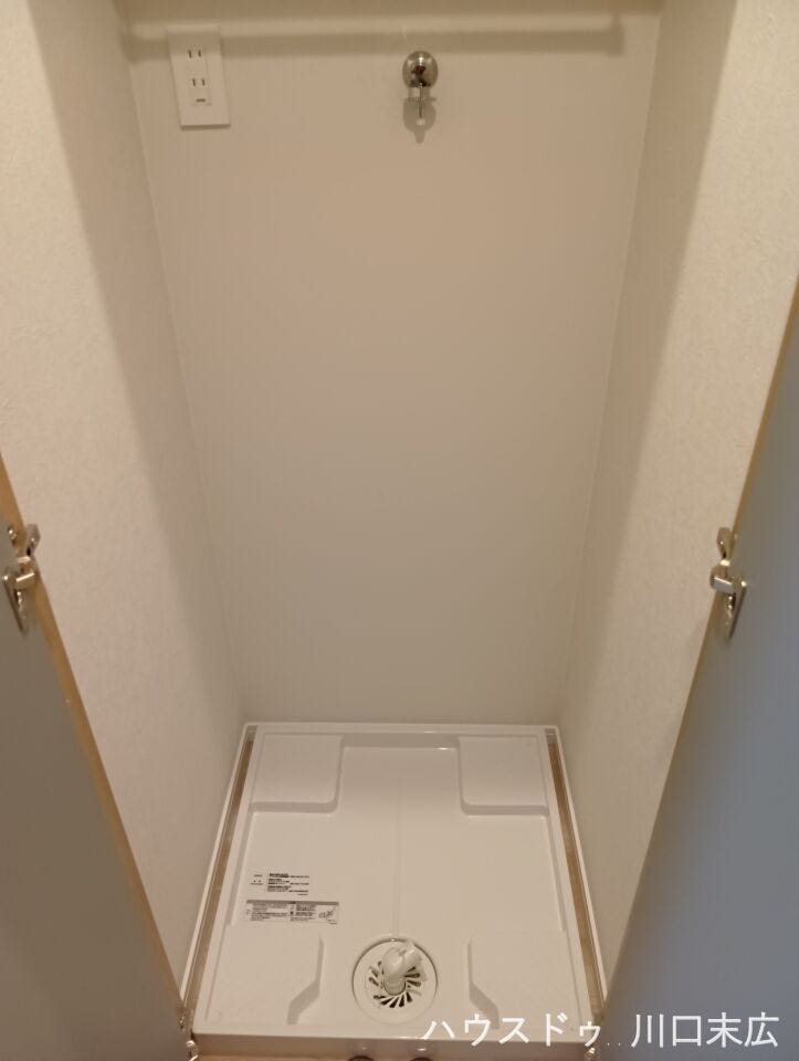 防水パンを備えた洗濯機置場。扉付きの設計を採用しているため、来客時などは生活感を隠し、洗面空間全体をすっきりと見せることができるスマートな造りです。