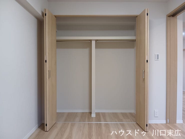 衣類や生活小物を機能的に収納できるクローゼット。ハンガーパイプと上部棚を備えており、丈の長いコートから鞄や帽子まで、整理整頓しやすい実用的な造りです。