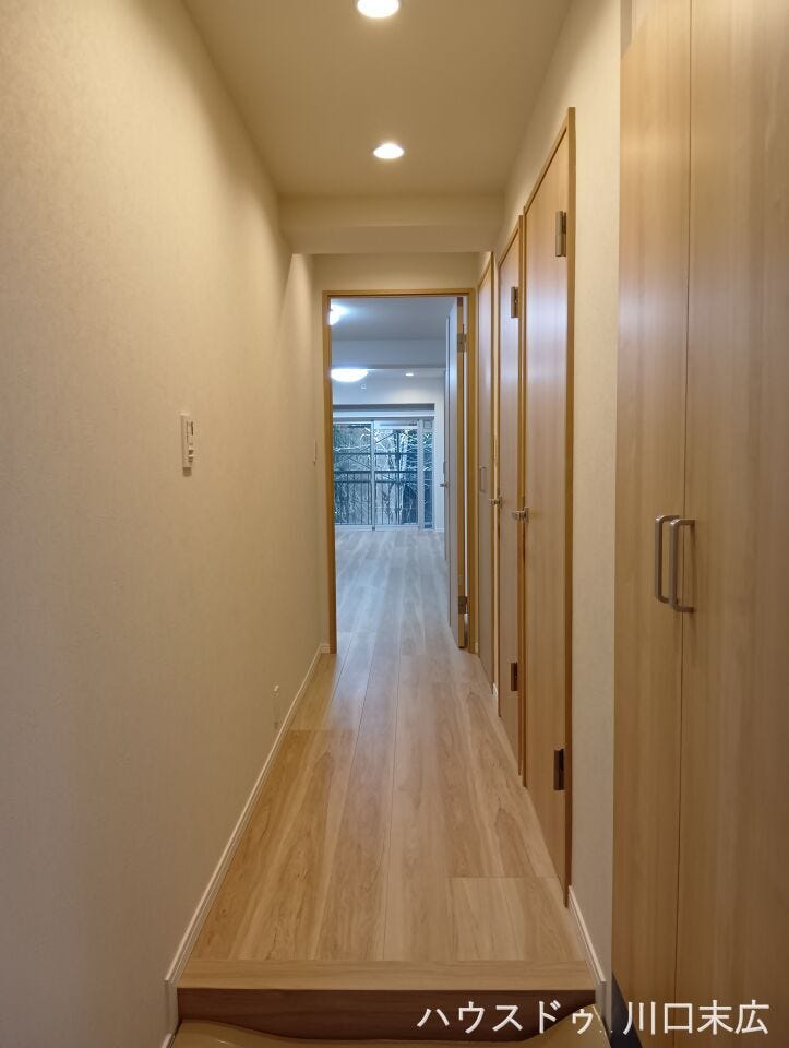各居室へと繋がる、木目調のフローリングが美しい廊下。生活動線に配慮された設計で、居住空間の独立性を高めつつ、家族のプライバシーをしっかりと守ります。