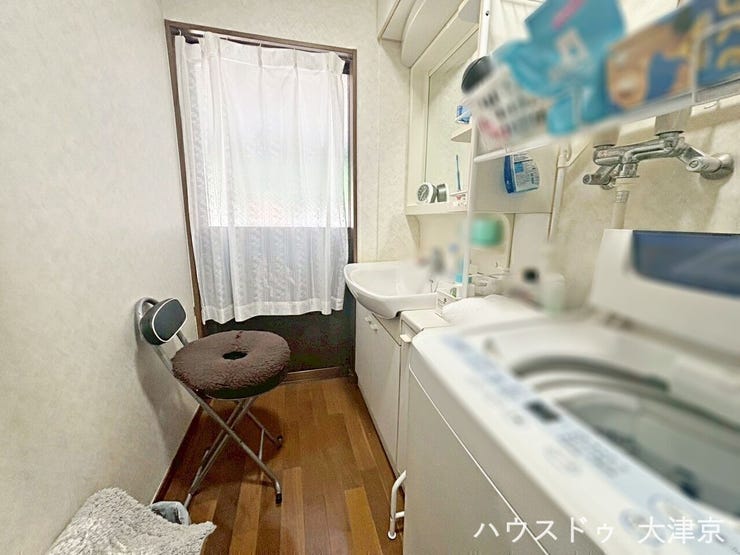 明るい窓付きで収納棚が多い洗面室