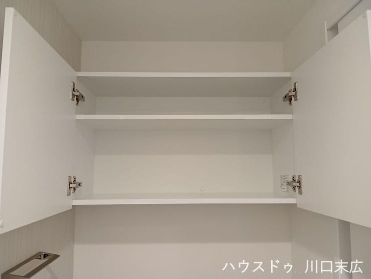 トイレの壁面に設けられた扉付きの吊り戸棚です。トイレットペーパーなどの備品や掃除用具を生活感を隠してすっきりと整理整頓でき、限られた空間を有効活用できる実用的で機能的な収納設備となっています。