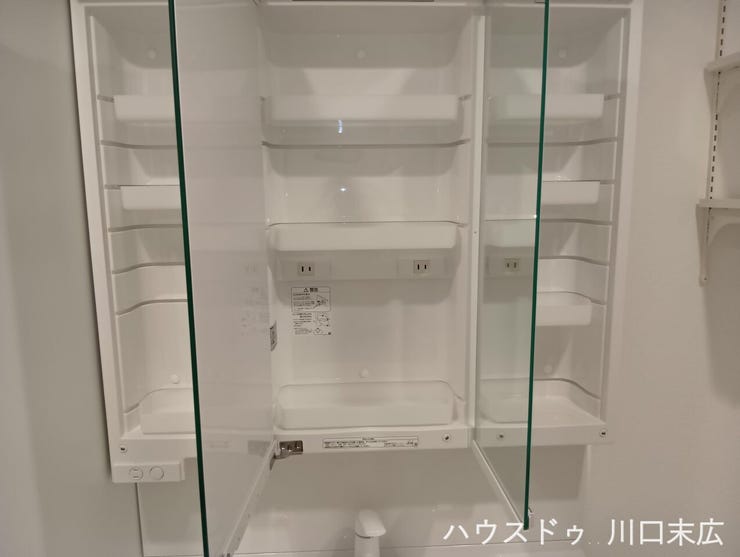 洗面化粧台の鏡裏に設けられた収納スペースです。コンセントを備えており、電動歯ブラシなどの充電も可能。慌ただしい朝の身支度をサポートし、細かい日用品を隠して整理できる実用的で使い勝手の良い設計です。